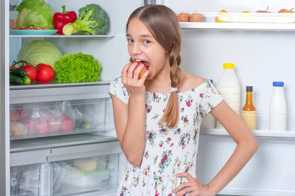 Dívka s jídlem v blízkosti lednice — Stock fotografie