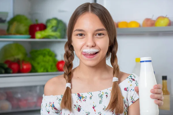 Chica con comida cerca de nevera — Foto de Stock