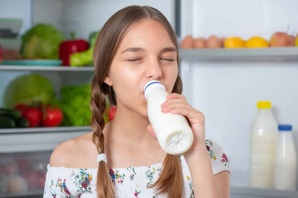 Flicka med mat nära kylskåp — Stockfoto