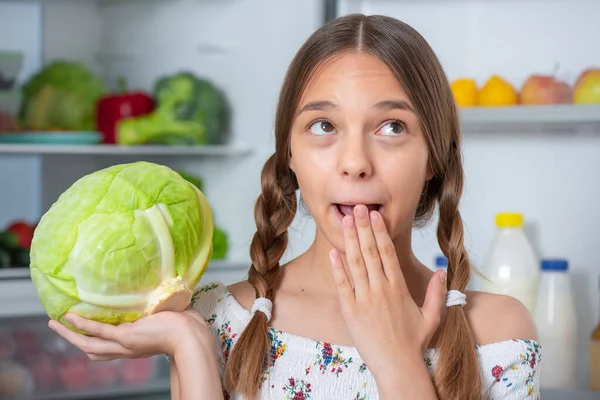 冷蔵庫の近くの食べ物を持つ女の子 — ストック写真