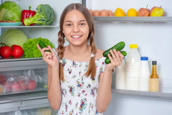 冷蔵庫の近くの食べ物を持つ女の子 — ストック写真
