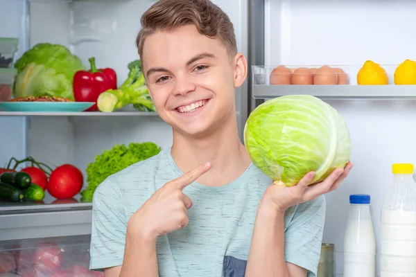 Jongen met eten in de buurt koelkast Rechtenvrije Stockfoto's