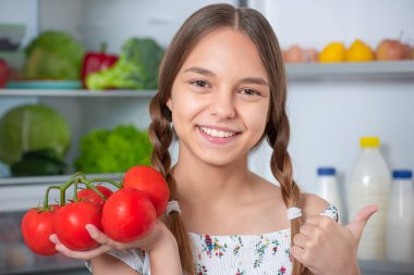 Buzdolabının yanında yemeği olan kız.