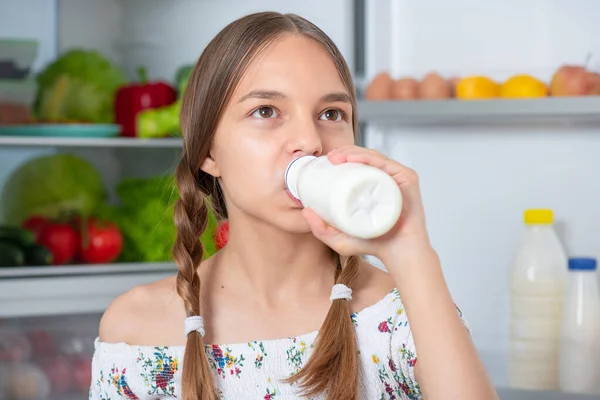 Дівчина з їжею біля холодильника — стокове фото