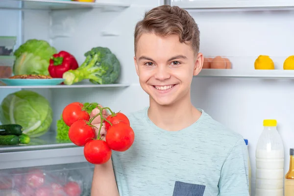 冷蔵庫の近くの食べ物を持つ少年 — ストック写真