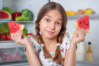 Buzdolabının yanında yemeği olan kız.