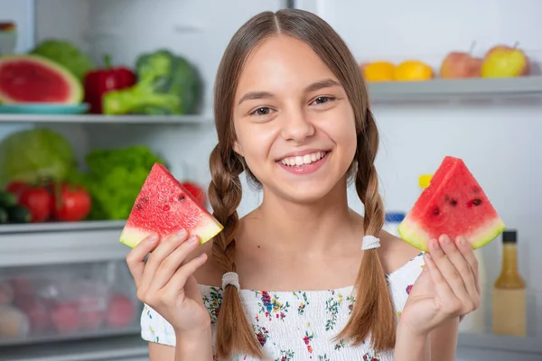 Dívka s jídlem v blízkosti lednice — Stock fotografie