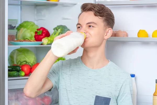 Pojke med mat nära kylskåp — Stockfoto