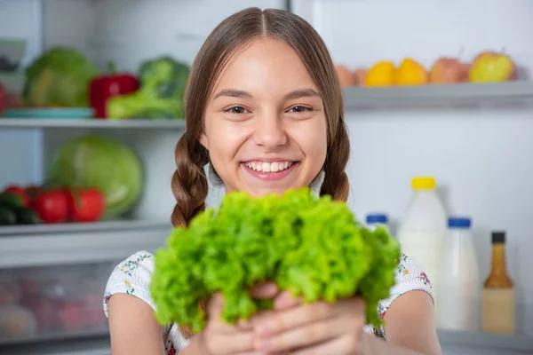 Flicka med mat nära kylskåp — Stockfoto