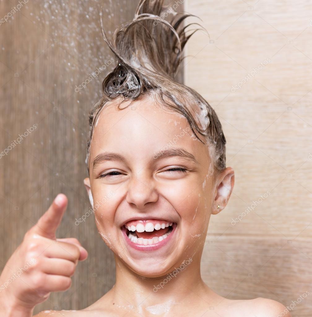 Smiling young girl bathing under a shower at home. Beautiful teen girl  taking shower and washing in the bathroom. Happy child washing head, face  and body with water. Stock Video