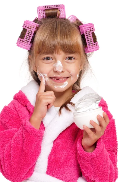 Kleines Mädchen im rosa Bademantel mit Lockenwicklern und Creme — Stockfoto