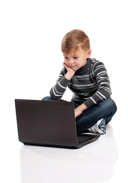 Chłopiec siedzi na podłodze z laptopa — Zdjęcie stockowe