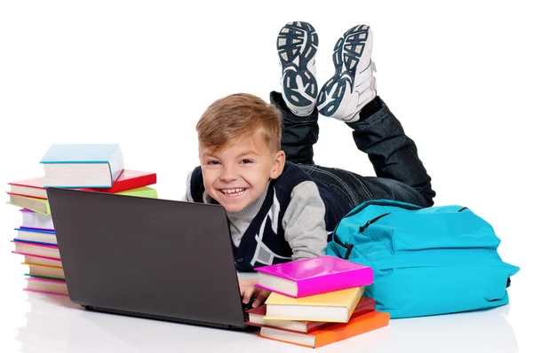 Gelukkig schooljongen liggend op de vloer met laptop — Stockfoto