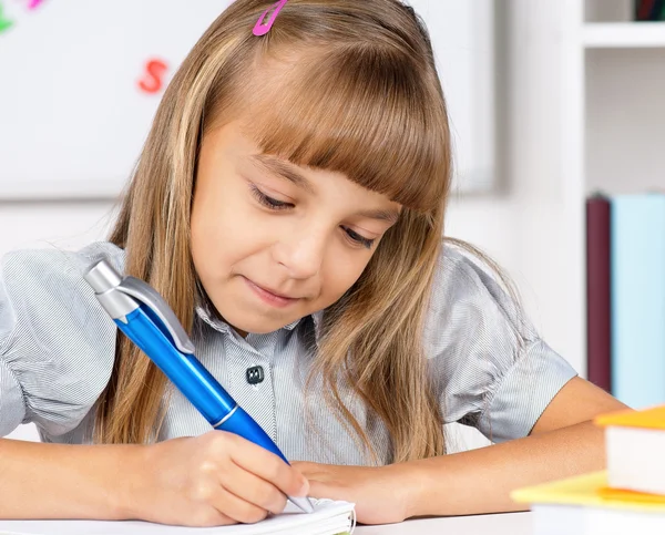 Bambina che fa i compiti a tavola. — Foto Stock