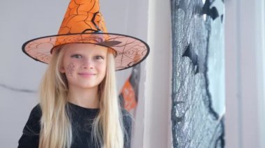 4 bin. Cadı kostümlü mutlu sarışın kız evde Cadılar Bayramı için hazırlanıyor.