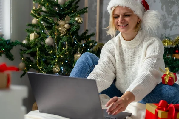 Świąteczne zakupy online. Kupiec zamawia na laptopie. Kobieta kupuje prezenty, przygotowuje się do świąt, wśród pudełek i opakowań. Sprzedaż wakacji zimowych. — Zdjęcie stockowe