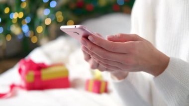4 bin. Noel arka planında cep telefonu kullanarak kadın ellerini kapat. İnternetten alışveriş. Kadın alıcı siparişleri alır, hediyeleri alır ve Xmas 'a hazırlanır. Yeni yıl satışları.