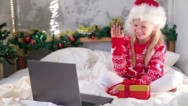 4k Weihnachts-Online-Glückwünsche von zu Hause. Lächelndes Mädchen mit Notebook-Laptop für Videoanrufe. Kind redet mit Freunden und Eltern — Stockvideo