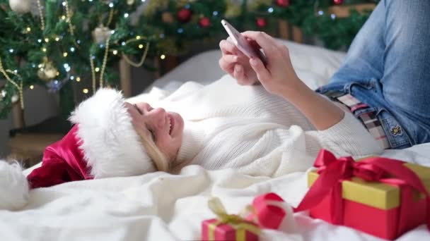 4k Weihnachten Online-Shopping, Arbeit und Bildung. Frau mit Handy zu Hause in Weihnachtsmütze. Winterschlussverkauf. — Stockvideo