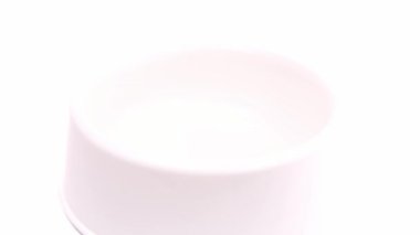 Yavrular için 4k kuru yiyecek beyaz arka plandaki büyük beyaz kaseye dökülür. Evcil hayvanlar besleniyor