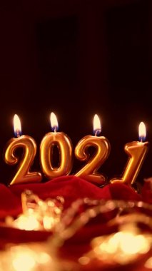 Mutlu yıllar 2021 kutlamaları. Noel arkaplanında 2021 numara şeklinde altın yanan mumlar. Dikey video. Metin için kopyalama alanı