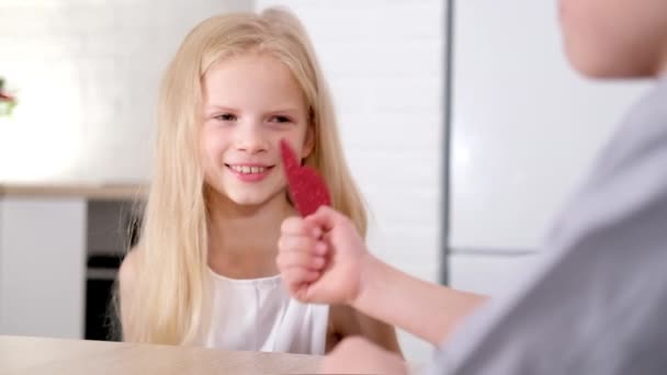 Malý chlapec dává své milované dívce Valentines Day červený dárek. Šťastně se usmívající blonďaté děti slaví Valentýna. Zpomalený pohyb. — Stock video