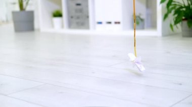  Çizgili kedi yavrusu modern iç mekanda iple kağıt yay ile oynuyor. Kedi zıplaması komik poz veriyor. Kedicik patileriyle oyuncak yakalar. Yavaş çekim