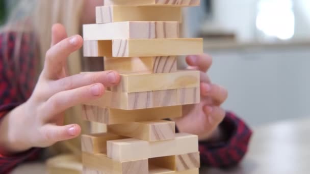 4k dzieci gra drewniany blok usuwania wieży gry w domu. Blondynka i chłopiec zabawy razem - gra planszowa i dzieci rekreacji koncepcja — Wideo stockowe