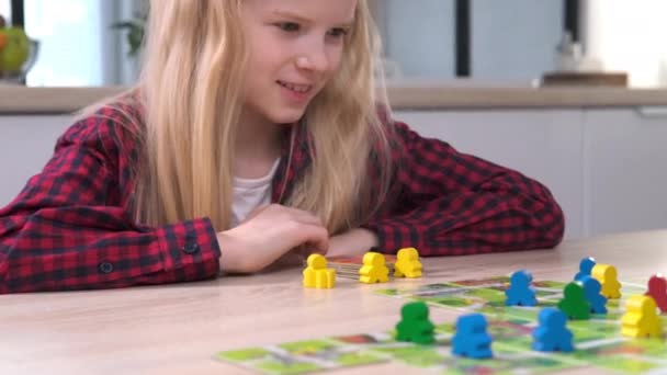 4k Board game and kids leisure concept - little blonde girl playing wood chips people figure in children table top game — Stock Video