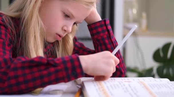 4k Blonde女学生在家里做作业。培训书籍和笔记本放在桌上。远程在线教育. — 图库视频影像