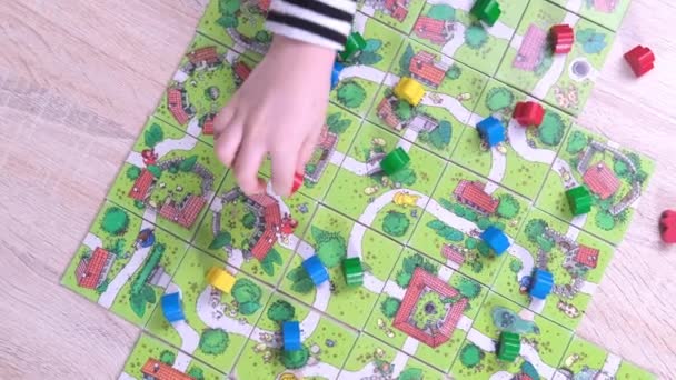 4k Board game and kids leisure concept - kids hands playing wood chips people figure in children table top game carcassonne - 11jan21 St.Petersburg Russia — Αρχείο Βίντεο