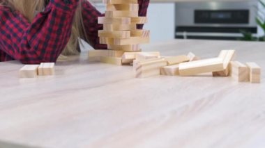 4K çocuklar evlerinde tahta blokları kaldırma oyunu oynuyorlar. Sarışın kız ve oğlan birlikte eğleniyor. Masa oyunu ve çocukların eğlence konsepti.