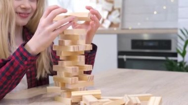 4K çocuklar evlerinde tahta blokları kaldırma oyunu oynuyorlar. Sarışın kız ve oğlan birlikte eğleniyor. Masa oyunu ve çocukların eğlence konsepti.