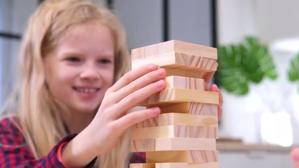 4k barn leker trä block borttagning torn spel hemma. Blond flicka och pojke att ha kul tillsammans - Brädspel och barn fritid koncept — Stockvideo