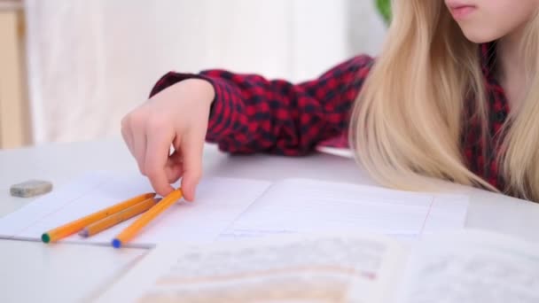 4k écolière blonde étudiant à la maison faisant des devoirs scolaires. Livres de formation et cahiers sur table. Enseignement à distance en ligne. — Video
