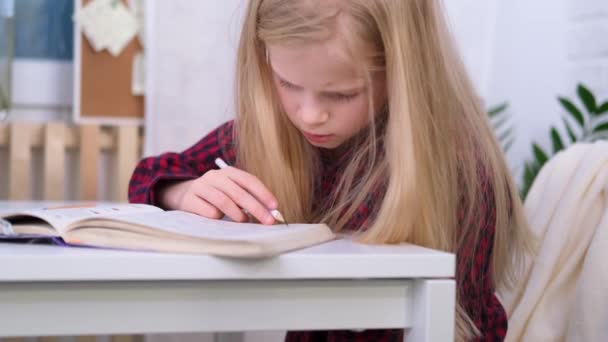 4k Blonde女学生在家里做作业。培训书籍和笔记本放在桌上。远程在线教育. — 图库视频影像