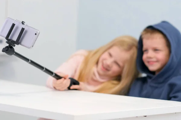 Niños bloggers hablando con seguidores, transmisión en vivo, mirando a la pantalla del teléfono inteligente en casa. Boy and Girl haciendo selfie o llamar a amigos y padres. Redes sociales, instagram, quedarse en casa y cuarentena —  Fotos de Stock