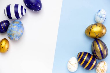 Mutlu Paskalyalar. Paskalya yumurtalarından yapılmış metin çerçevesi. Renkli klasik mavi, beyaz ve mavi üzerine altın rengi. Asgari biçim, üst görünüm, düz görünüm, kopyalama alanı.