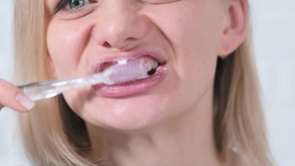 Porträtt ung kvinna med tandborste. Närbild medelålders kvinna ansikte borsta tänderna på vit tegel bakgrund. Hälsovård, tandhygien — Stockvideo