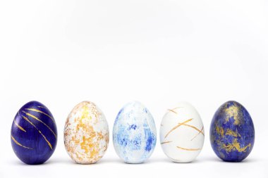 Mutlu Paskalyalar. Beş Paskalya yumurtası modaya uygun renkli klasik mavi, beyaz ve mavi üzerine altın rengi. Asgari biçim, üst görünüm, düz görünüm, metin için kopyalama alanı