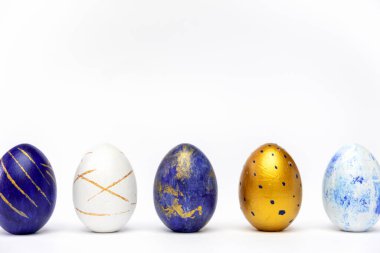 Mutlu Paskalyalar. Beş Paskalya yumurtası modaya uygun renkli klasik mavi, beyaz ve mavi üzerine altın rengi. Asgari biçim, üst görünüm, düz görünüm, metin için kopyalama alanı