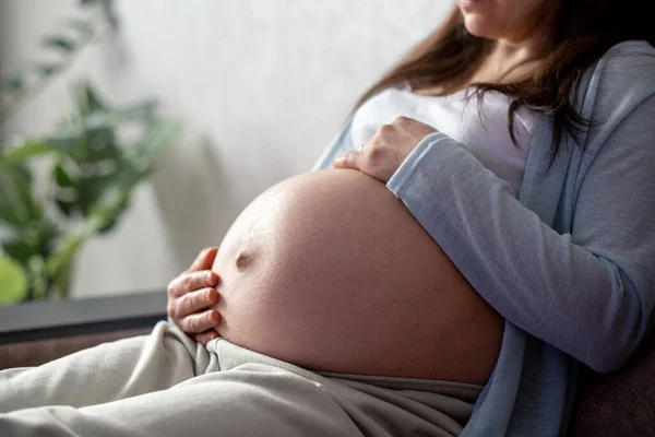 Здорова вагітність. вагітна жінка з великим черевом підвищена вагітність в руках. Банерна копія тексту. Модний колір, що освітлює жовті фіолетові кінцеві сірі . — стокове фото