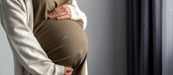 Здорова вагітність. вагітна жінка з великим черевом підвищена вагітність в руках. Банерна копія тексту — стокове фото