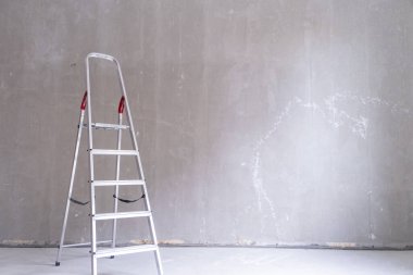 Yenileme dairesi. Evdeki boş duvarın yanındaki merdivenler. Bedava duvar, tamir evi. Metin için kopyalama alanı.