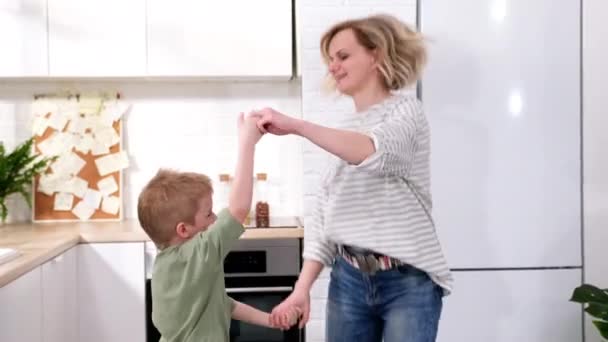 Nadšený maminka nebo hlídání dětí a kluk skákání tanec smích v moderním skandinávském domě kuchyně Happy rodina matka a syn baví hrát společně doma — Stock video