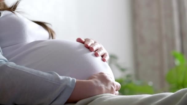 4k Vista laterale Madre incinta incinta che si accarezza la pancia. Mani di donna toccano la pancia, in attesa di bambino. Preparazione per il parto, Ragazza grande pancia gravidanza avanzata. — Video Stock