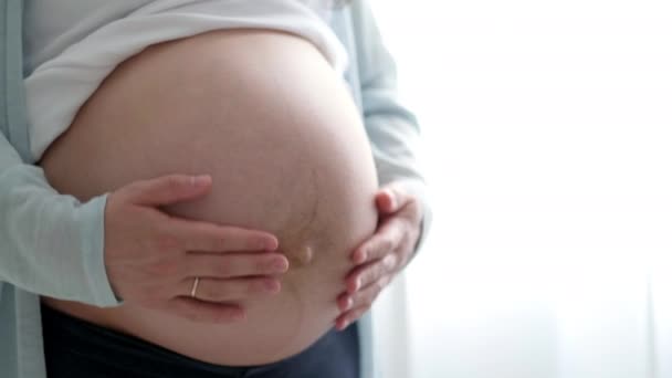 4k Zwangere aanstaande moeder strelen haar buik. Vrouw handen die haar buik aanraken, wachtend kind. Voorbereiding voor de bevalling, Meisje grote buik gevorderde zwangerschap. — Stockvideo