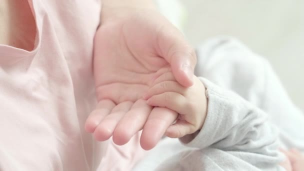 4k recién nacido bebé mano sosteniendo madre, mamá tocando bebé pequeña mano para hacerle sentir su amor, cálido y seguro. Maternidad, familia, concepto de nacimiento — Vídeos de Stock