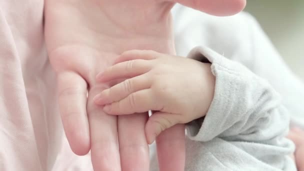 Мама трогает малыша крошечной рукой, чтобы он почувствовал ее любовь, тепло и безопасность. Материнство, семья, концепция рождения — стоковое видео