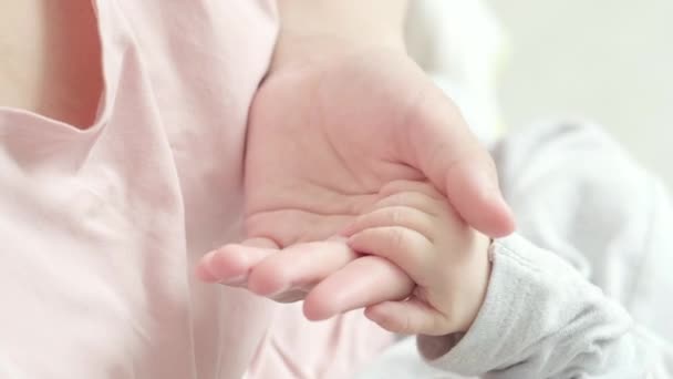 4k Yeni Doğmuş Bebek El Ele Tutuşan Anne, Anne minicik ellerine dokunarak ona sevgisini hissettirdi, sıcak ve güvenli. Annelik, aile, doğum kavramı — Stok video